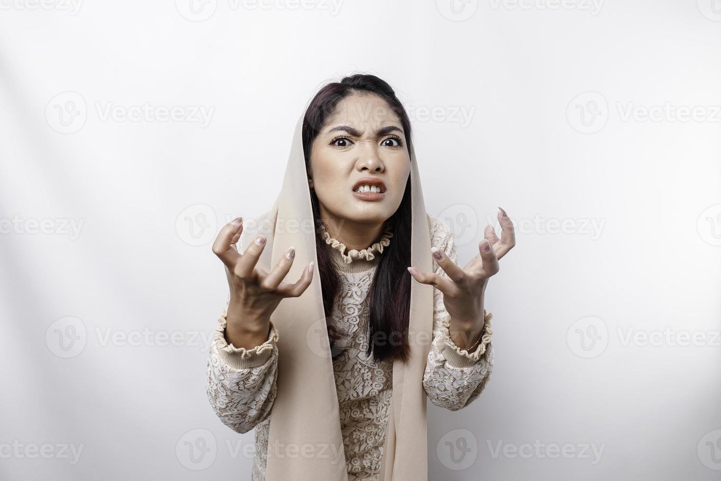 un retrato de un asiático musulmán mujer vistiendo un Pañuelo aislado por blanco antecedentes mira Deprimido foto