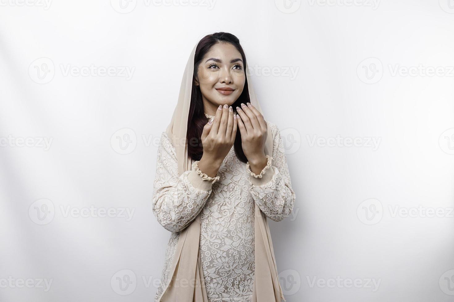 Religious beautiful Asian Muslim girl wearing a headscarf praying to God. photo