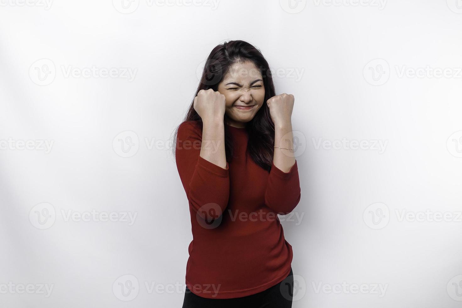 un joven asiático mujer con un contento exitoso expresión vistiendo rojo parte superior aislado por blanco antecedentes foto