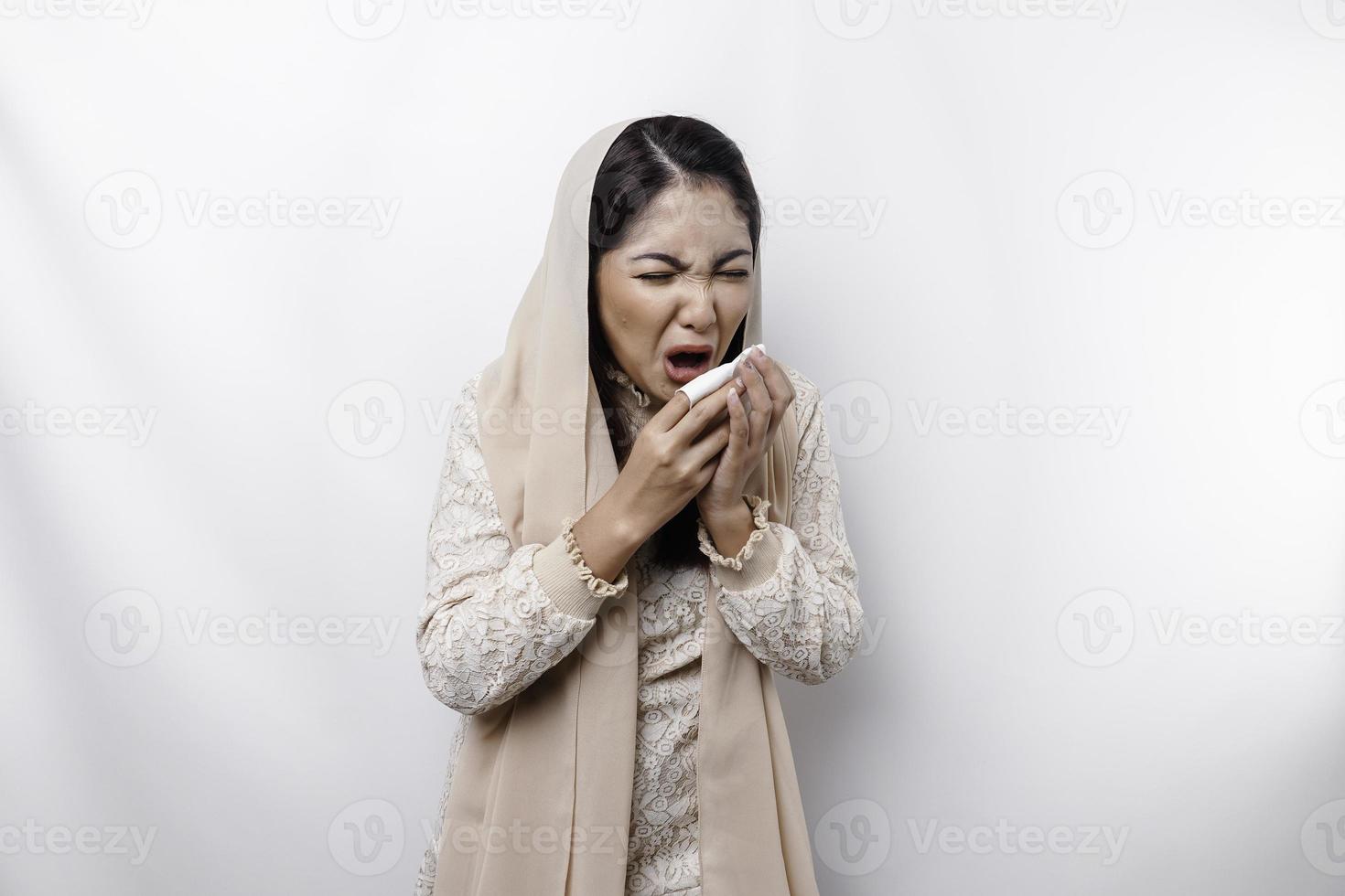 joven hermosa asiático musulmán mujer vistiendo Pañuelo en pie terminado aislado blanco antecedentes sensación indispuesto y tos como síntoma para frío o bronquitis. salud cuidado concepto. foto