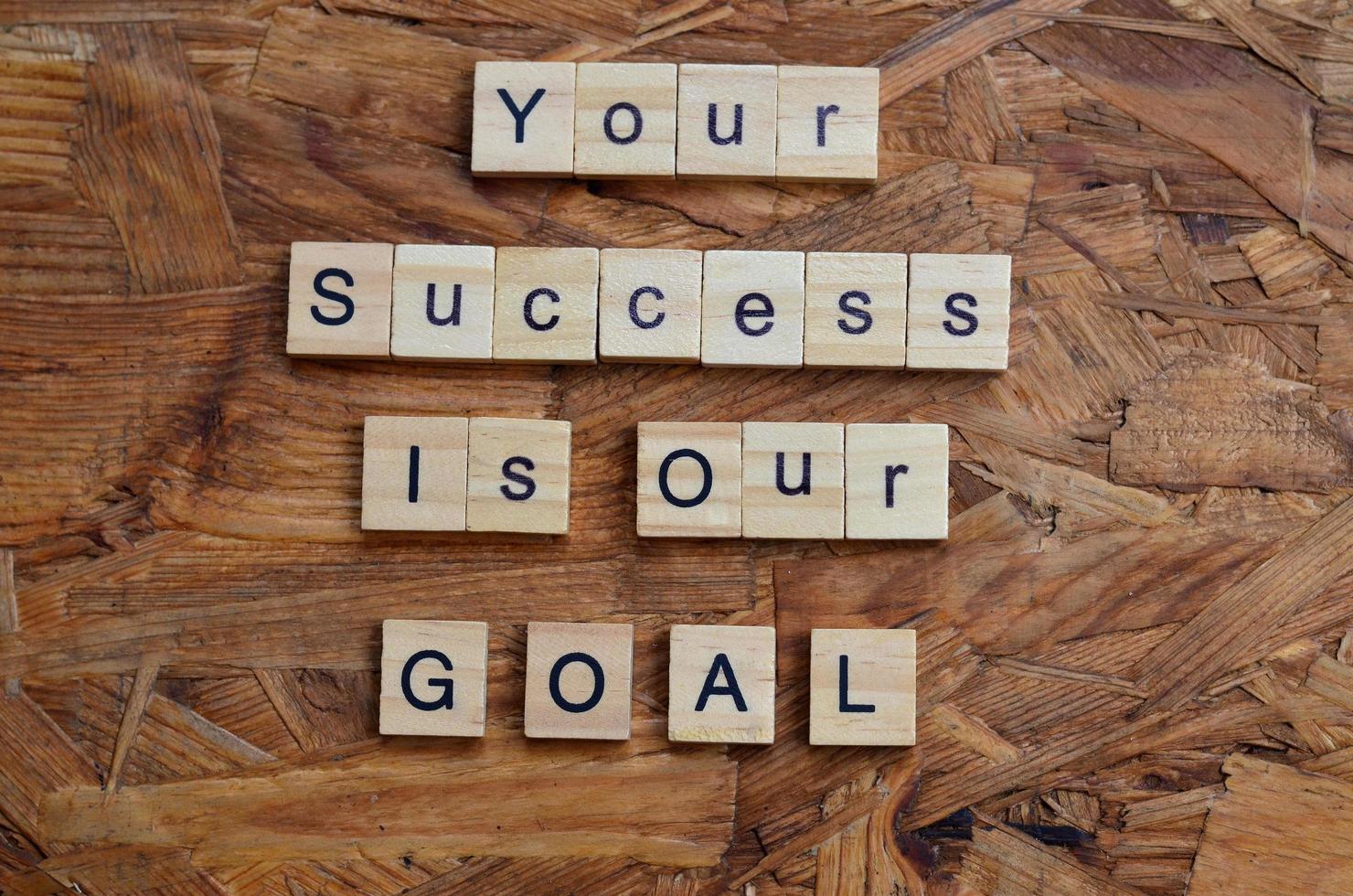 your success is our goal text on wooden square, business motivation quotes photo