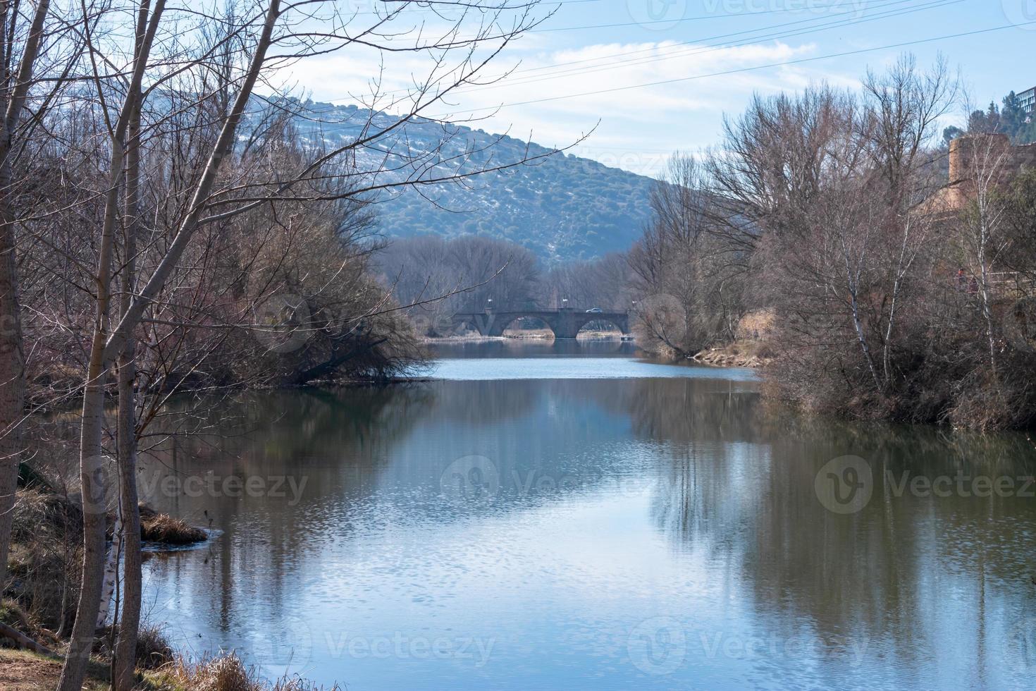 Duero river in the city of Soria in Spain with a stone bridge in the background photo