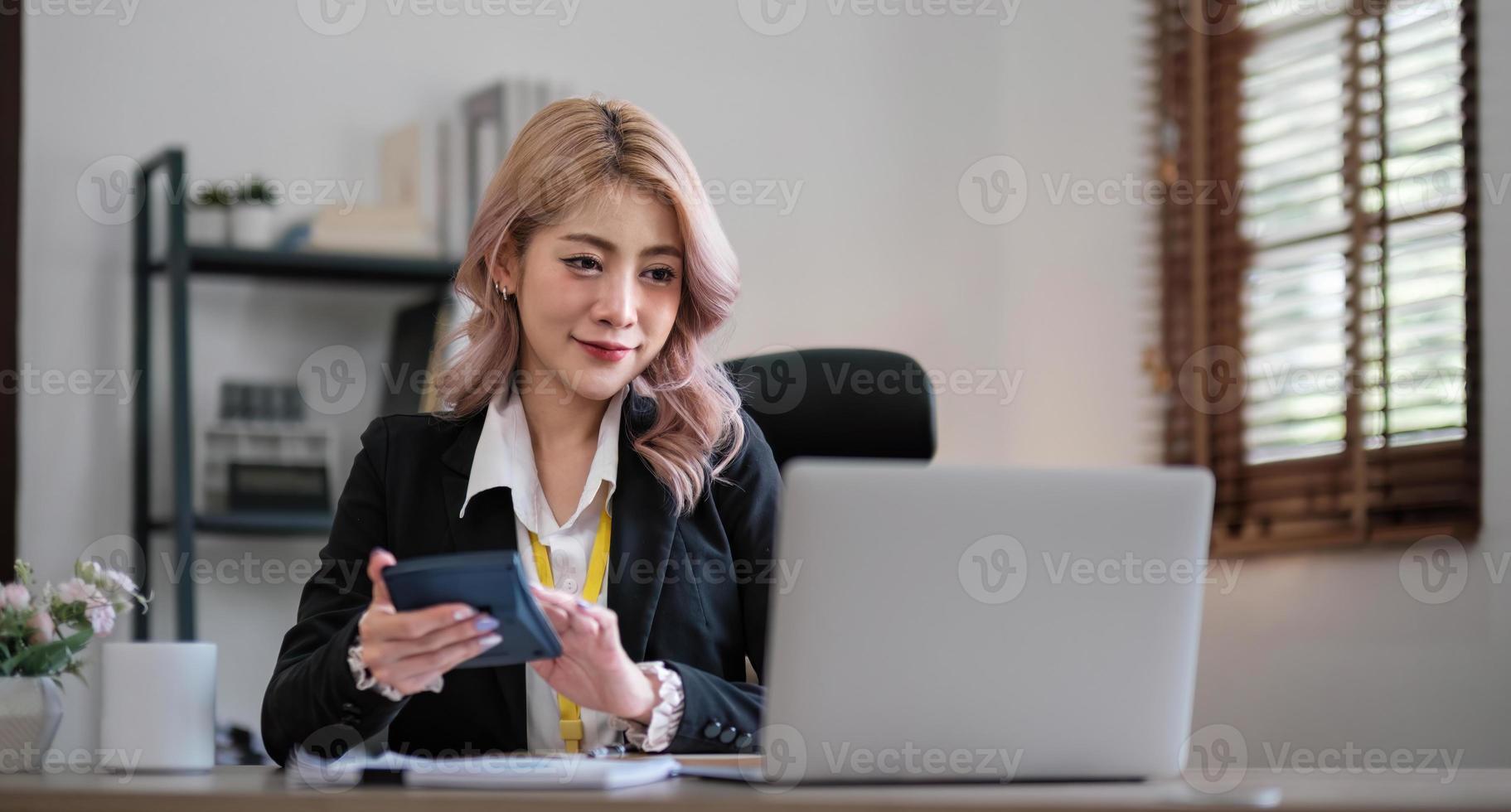 Business woman using calculator for do math finance on wooden desk in office and business working background, tax, accounting, statistics and analytic research concept photo
