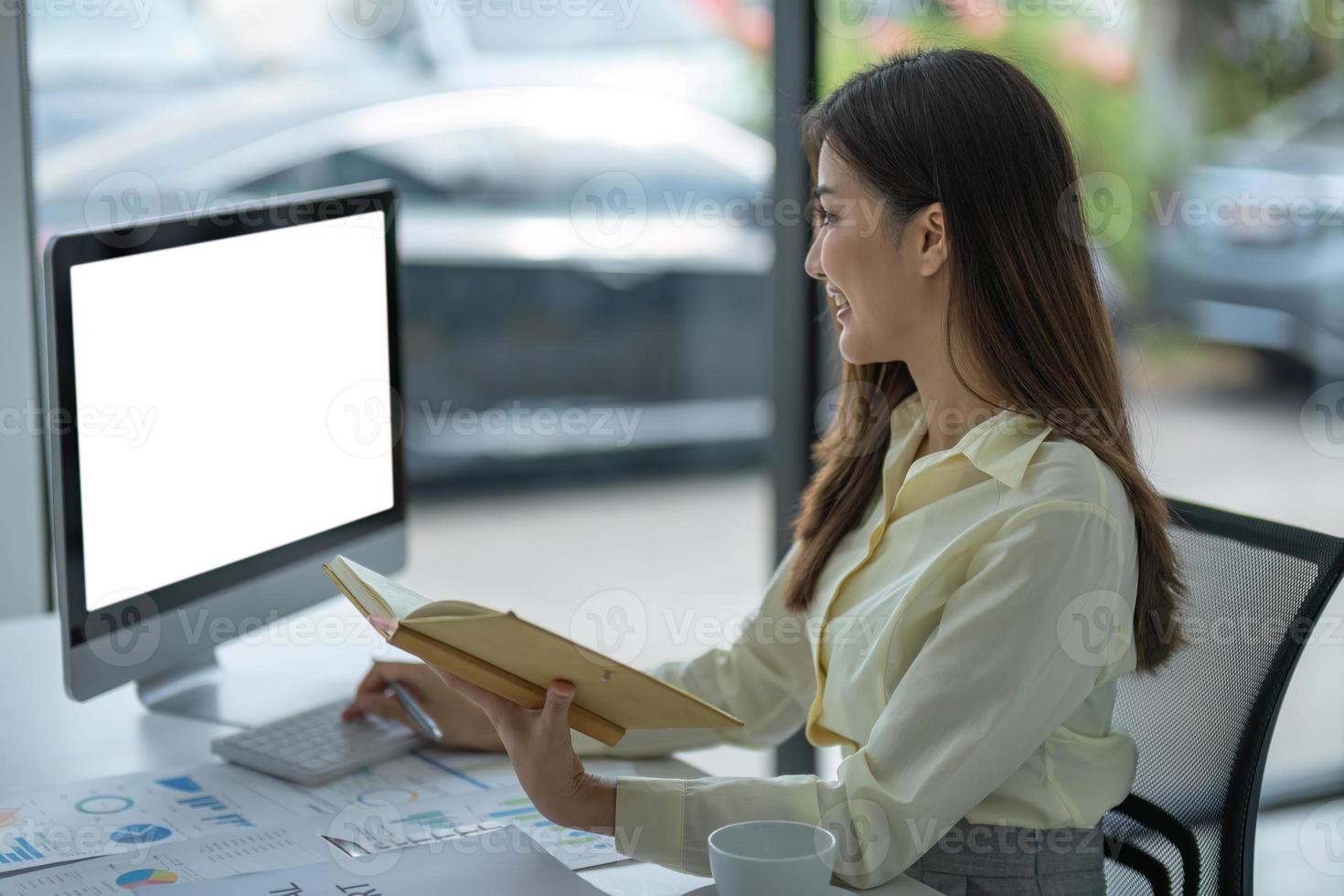 mujer mano utilizando ordenador portátil con burlarse de arriba blanco pantalla y tomando notas trabajo desde hogar concepto. foto