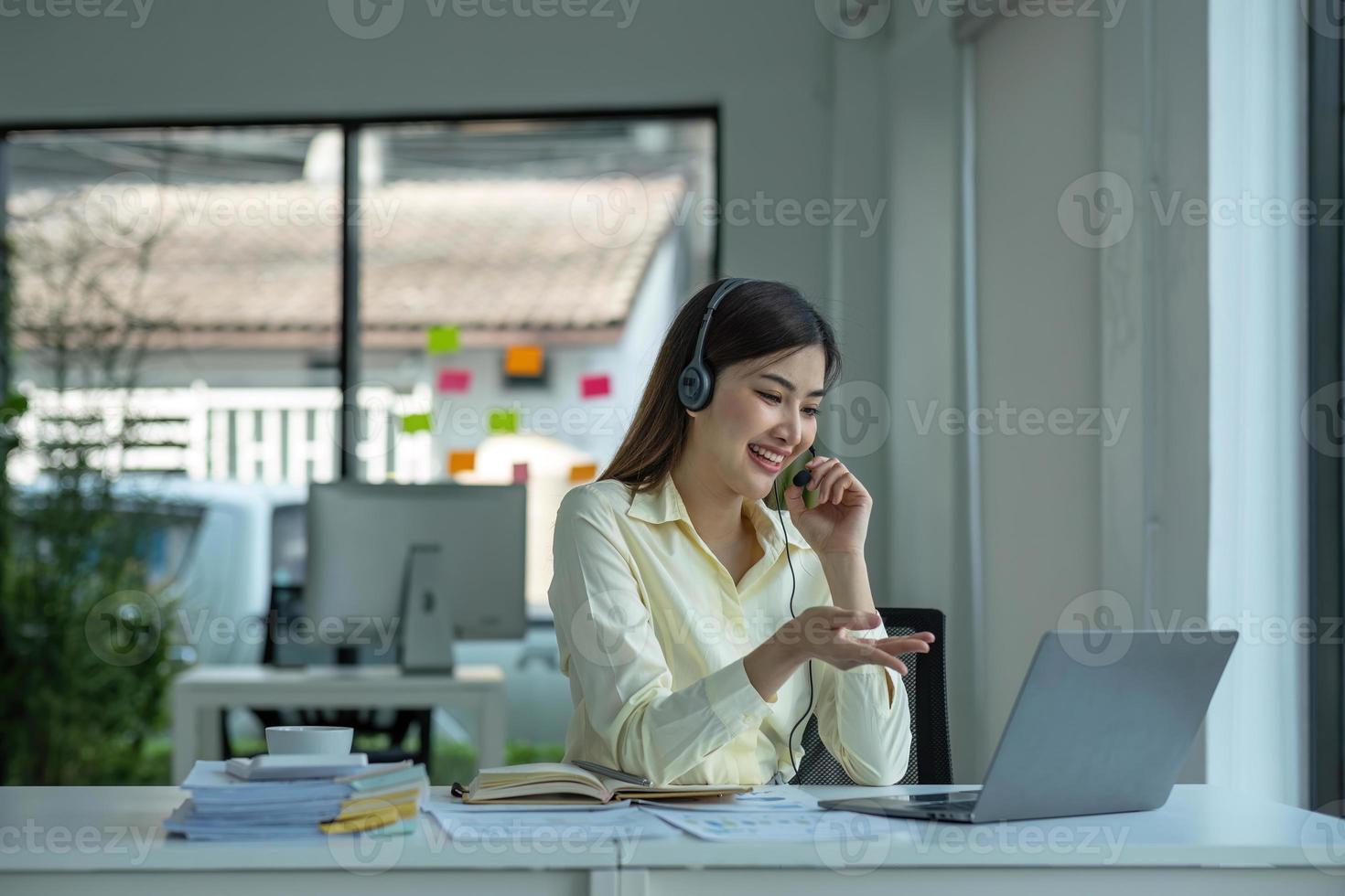 cerca arriba llamada centrar operador en inalámbrico auriculares hablando con cliente, mujer en auriculares con micrófono consultante cliente en teléfono en cliente apoyo servicio, mirando a computadora pantalla foto