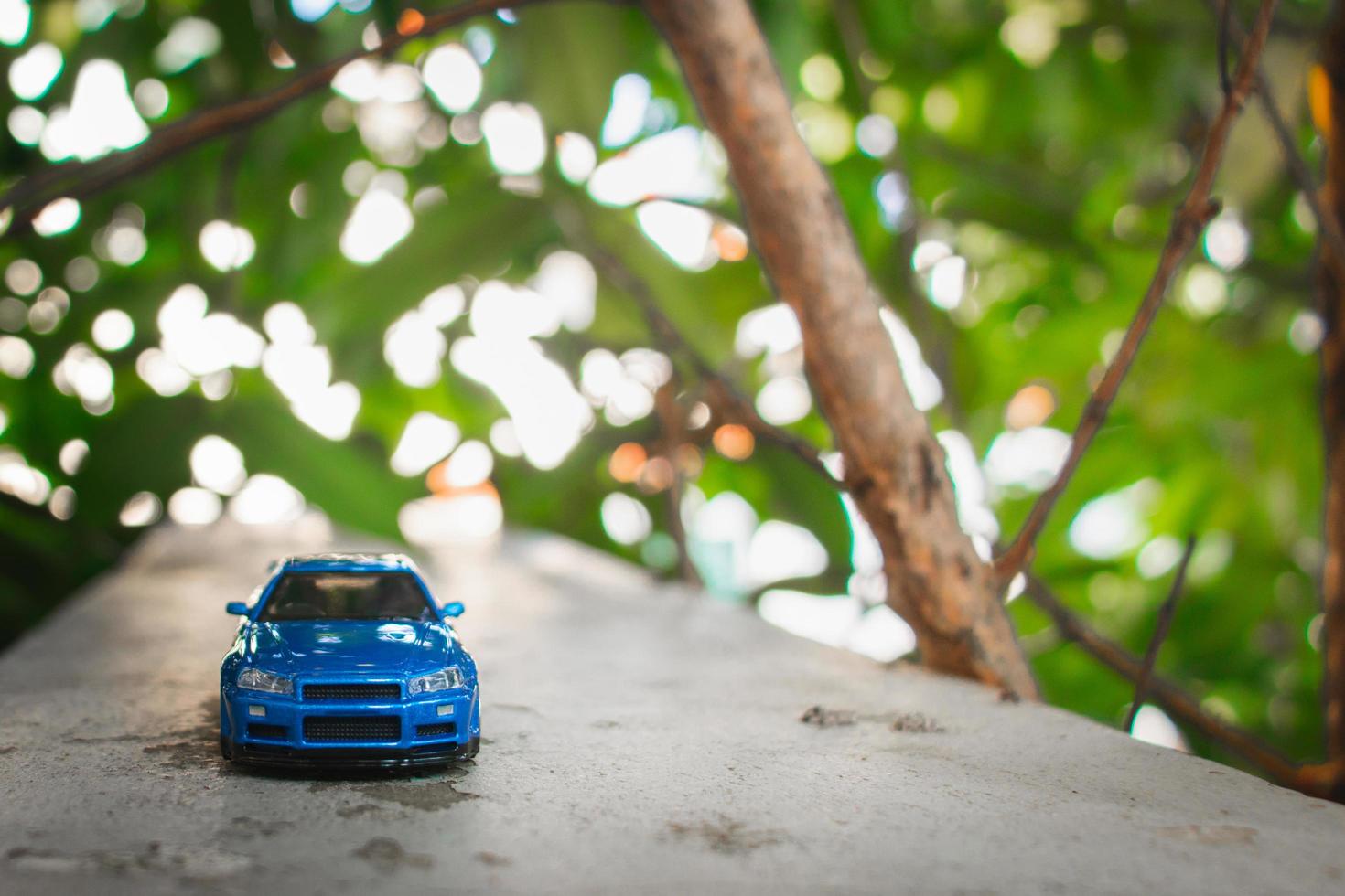 concepto para naturaleza aventura. después algunos ediciones, un foto de azul juguete coche metido cerca un árbol.