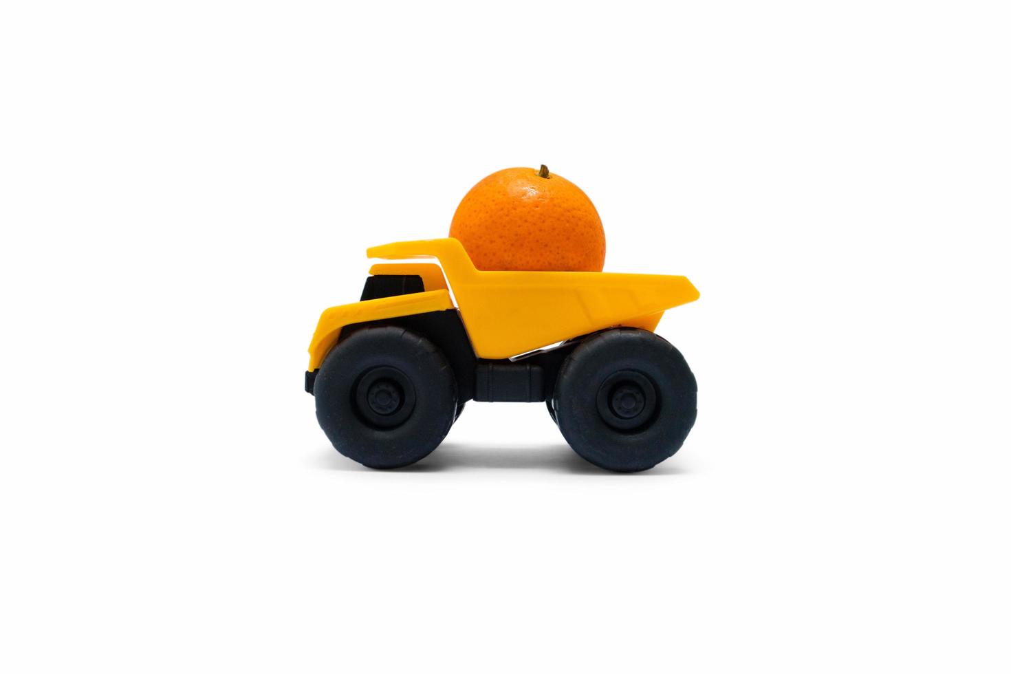A photo after some edits, a yellow truck tries to carry an orange.