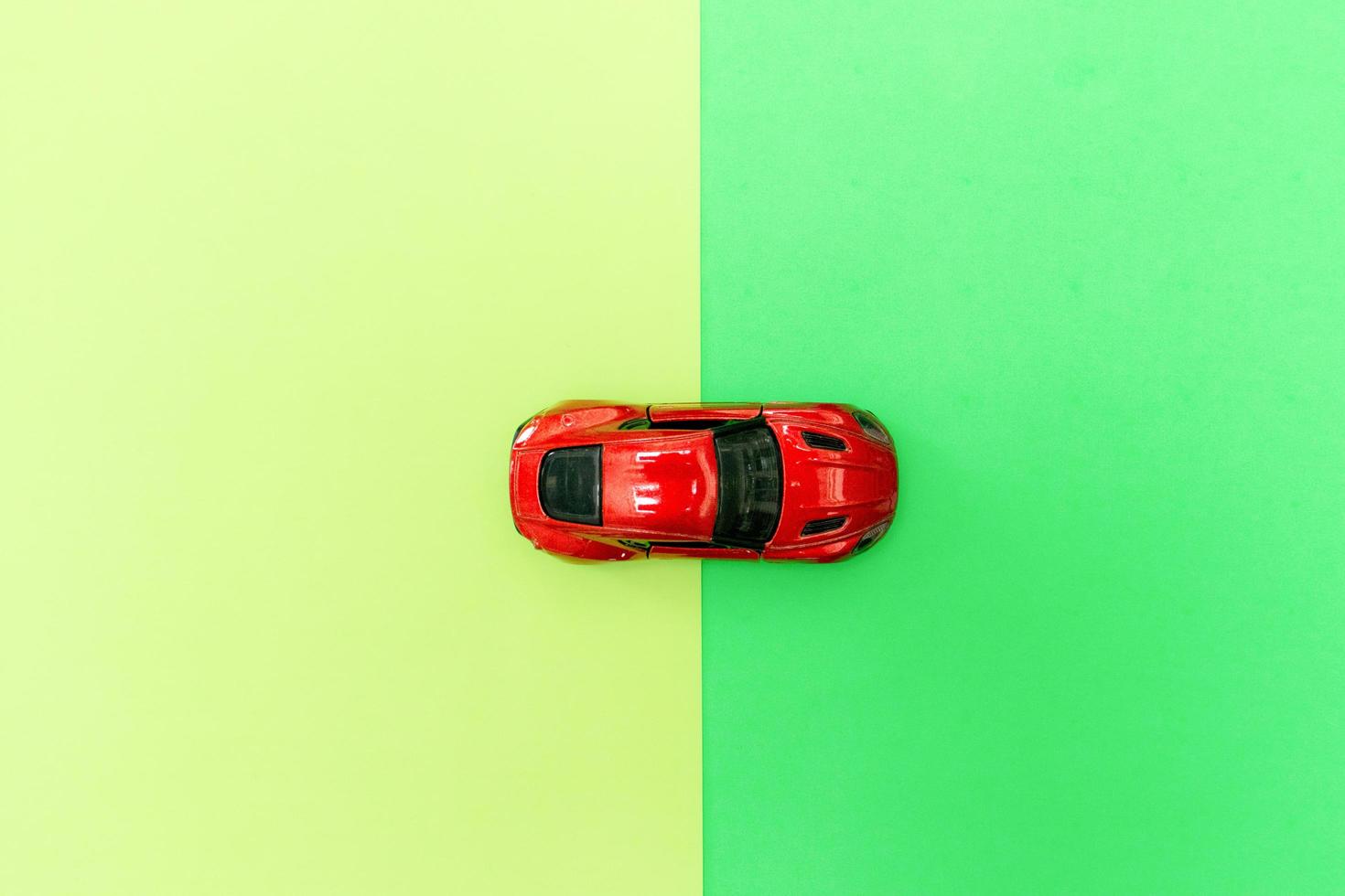 Red toy car isolated on two color background paper, after some edits. photo