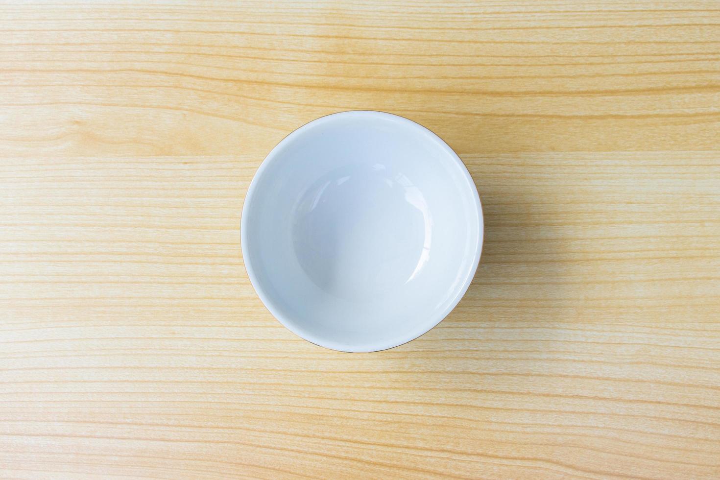An empty bowl isolated on wooden background, after some edits. photo