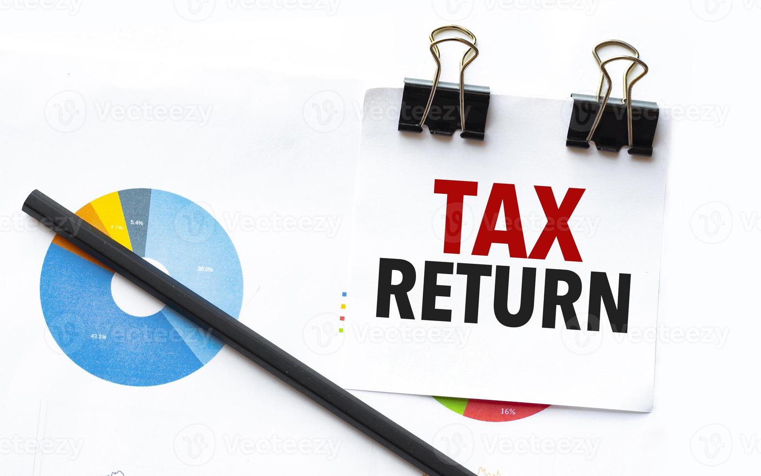 tax return on notebook with charts and pencil photo