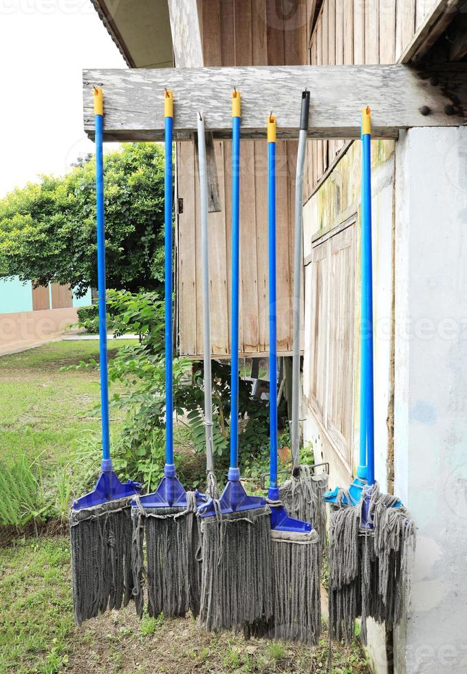 Mops after use hanged on wooden beam photo