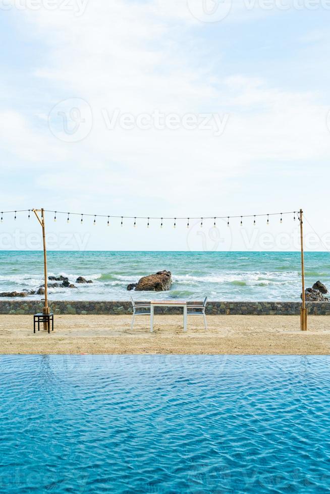 dinning table and chair on beach with sea background photo