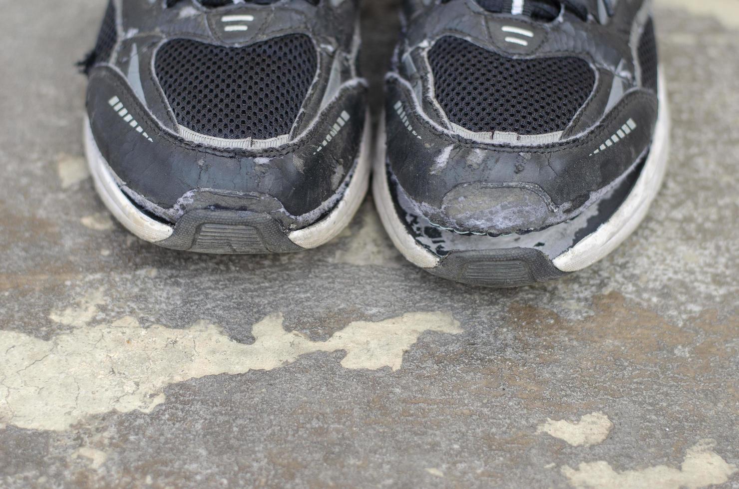 broken old black sneakers on the floor copy space photo