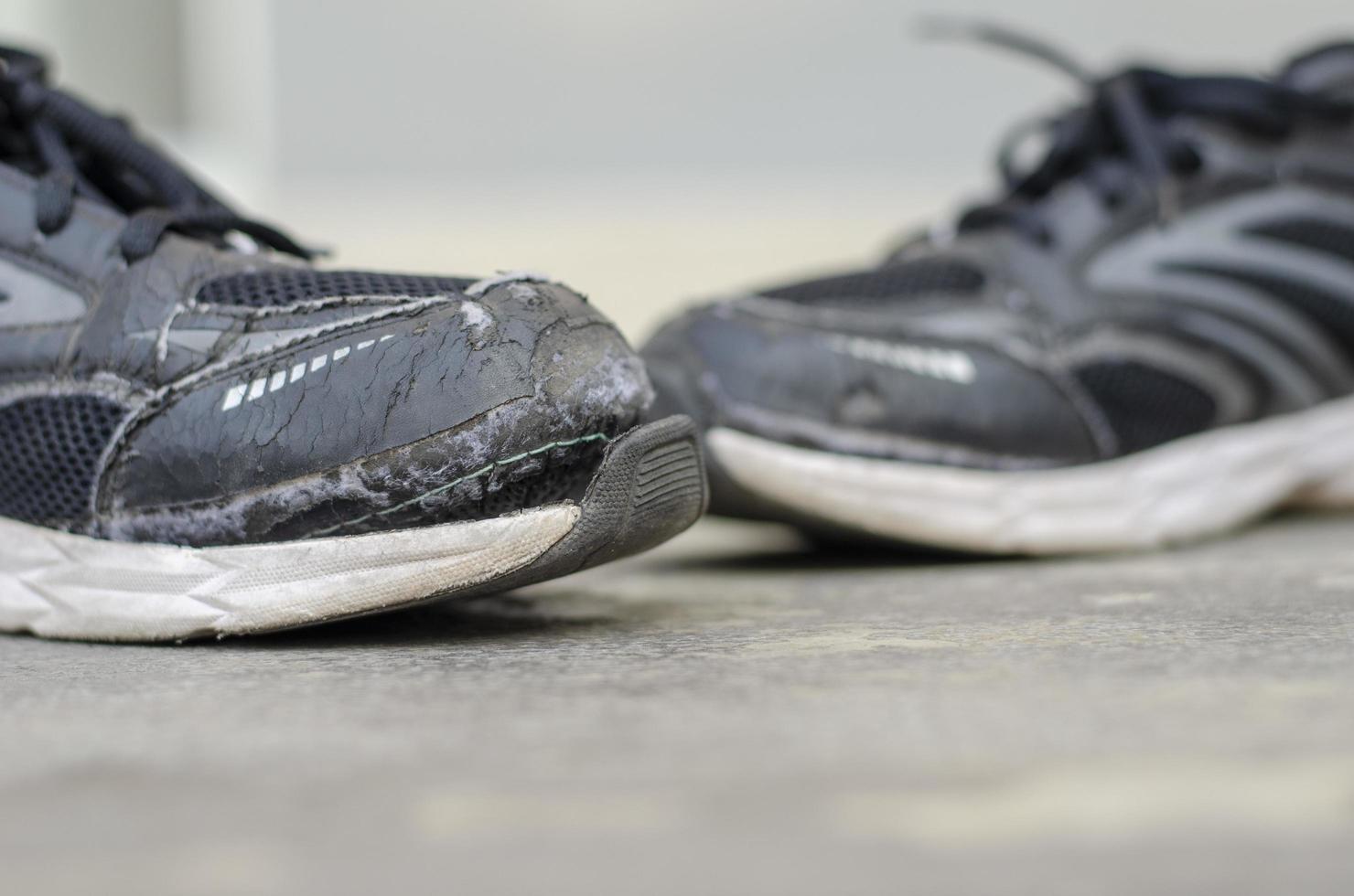 broken old black shoes on the floor. copy space photo