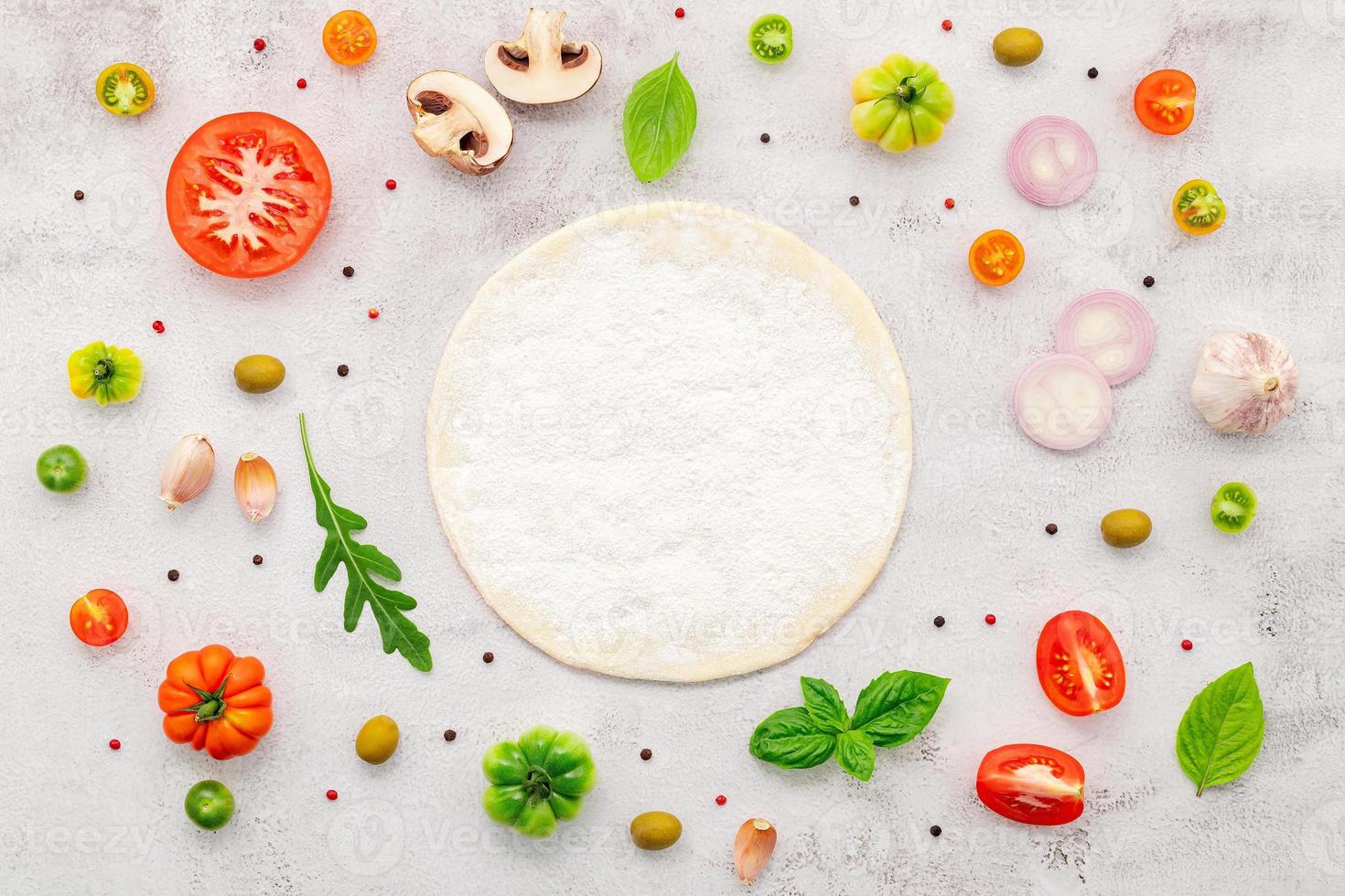 The ingredients for homemade pizza set up on white concrete background. photo