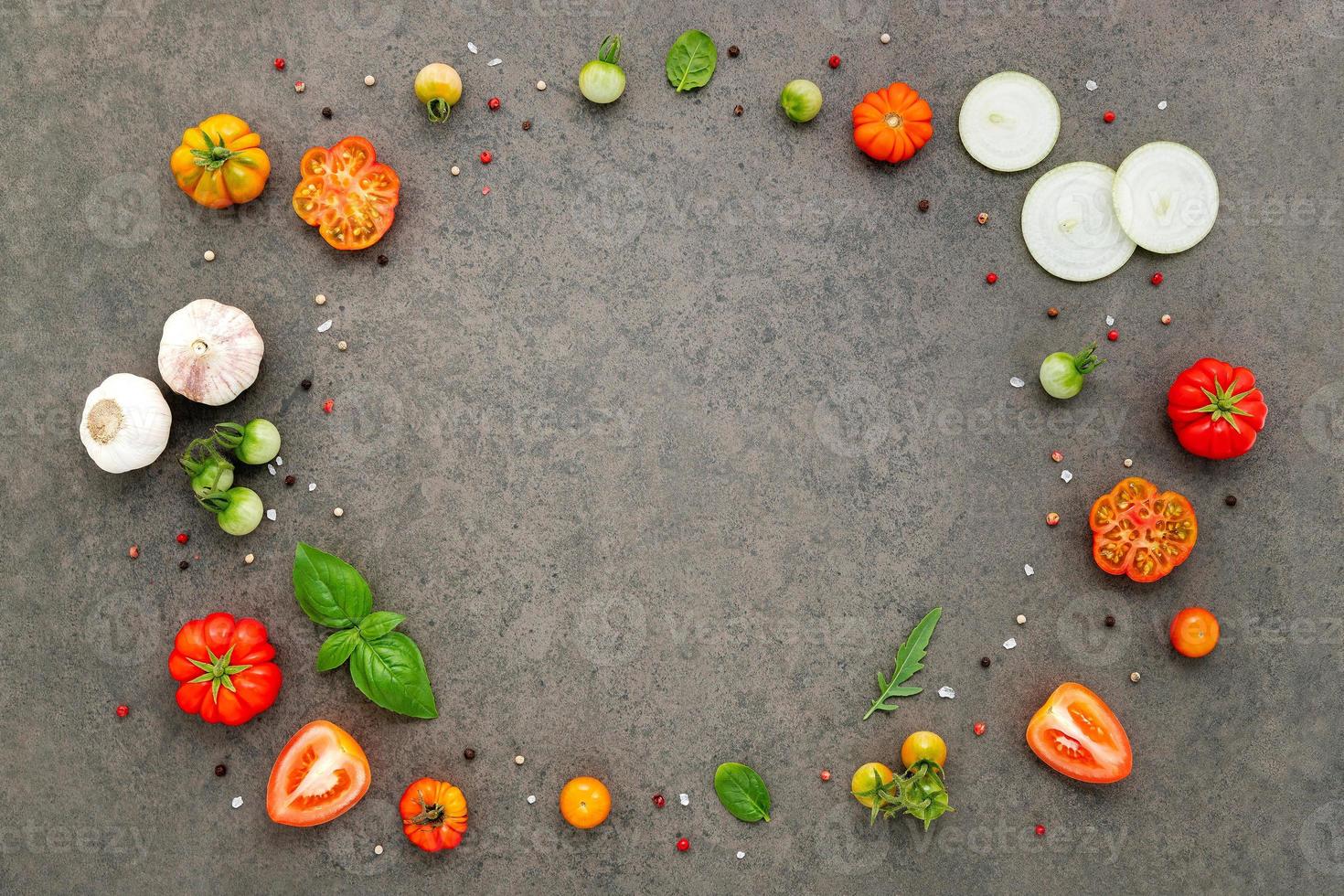 The ingredients for homemade pizza set up on dark stone background. photo