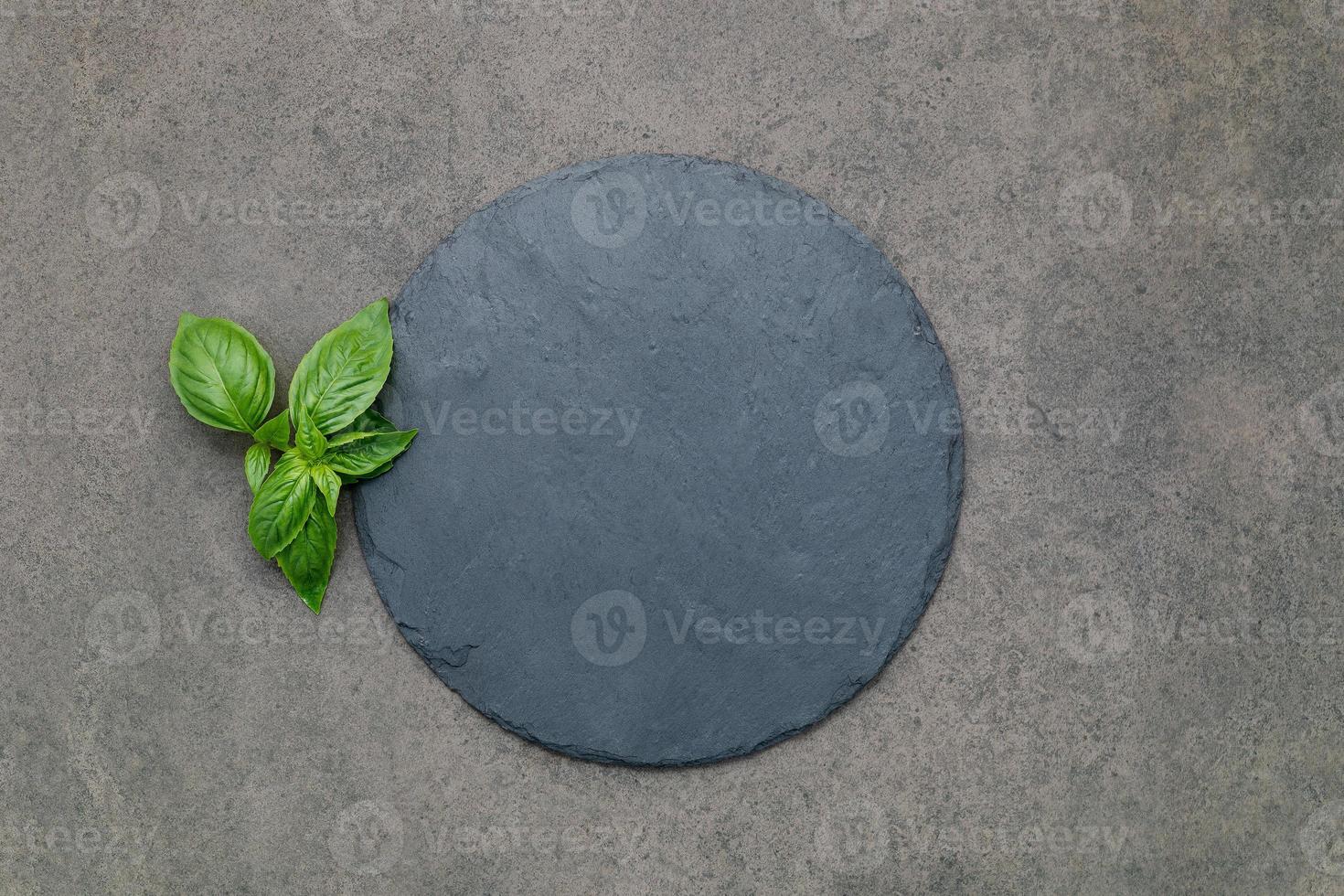 Empty pizza platter for homemade baking set up on dark concrete. Food recipe concept on dark stone background texture with copy space. photo