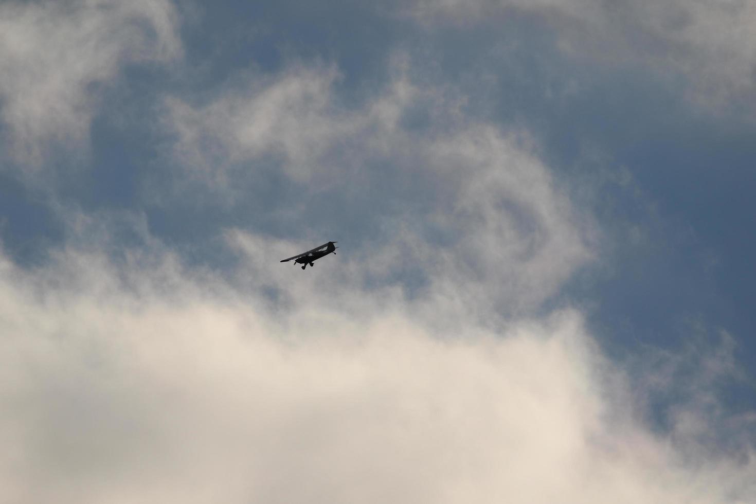 Small plane flying in the sky against dark clouds photo