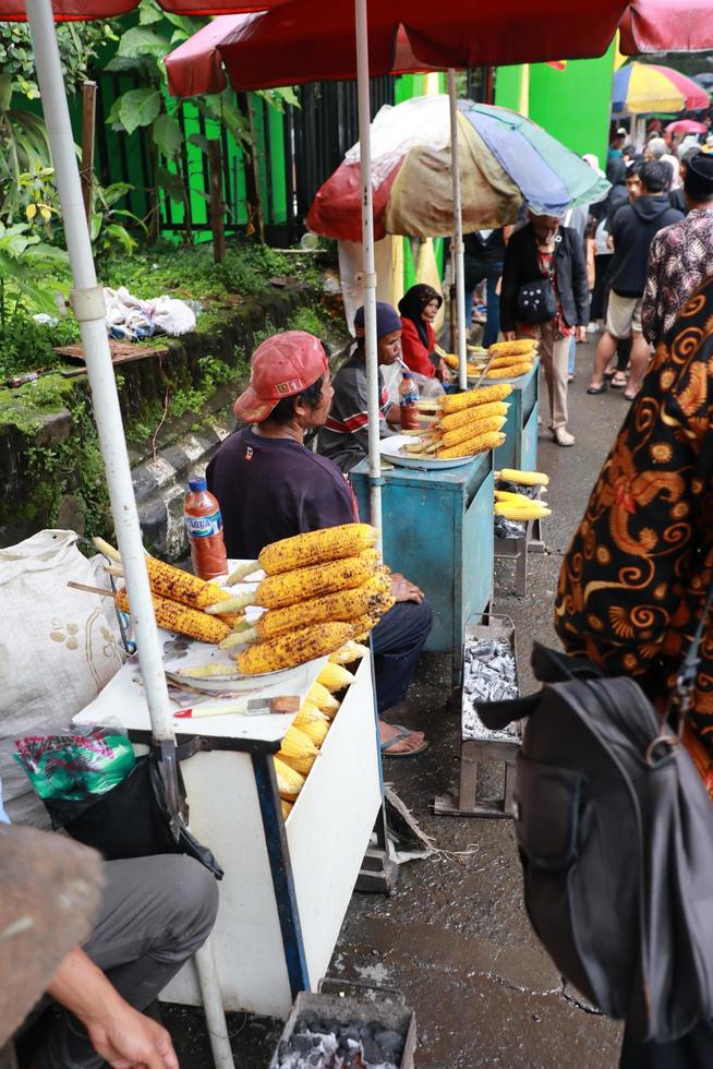 tegal, enero 2023. foto de un asado maíz vendedor en el lado de el gucci turista la carretera. concurrido con visitantes a disfrutar dulce y calentar asado maíz.