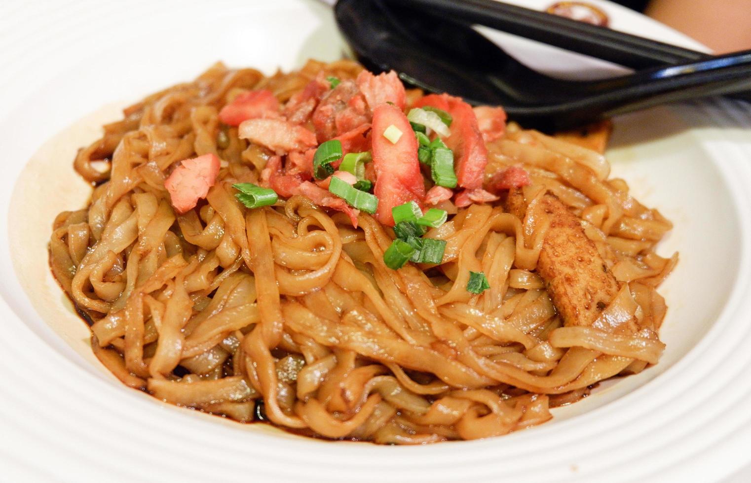 Noodle Fried soy sauce with roasted red pork on plate Malaysian food photo