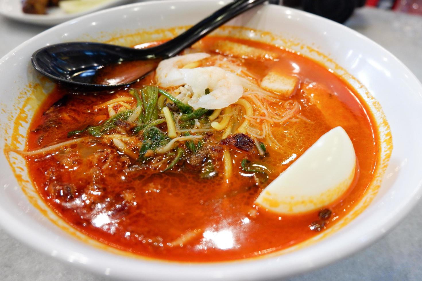 Curry soup seafood shrimp with coconut milk and vegetables herbal spices spicy in bowl Malaysian food noodle soup photo