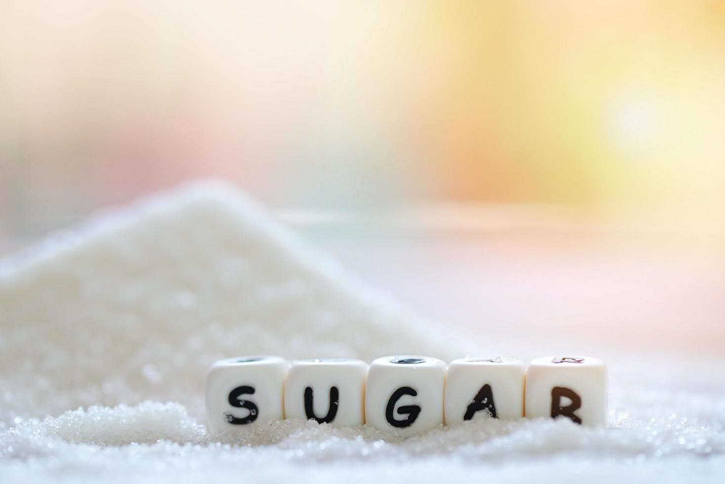 azúcar en el fondo borroso de la naturaleza, azúcar blanco para alimentos y dulces dulces de postre montón de azúcar dulce granulado cristalino foto