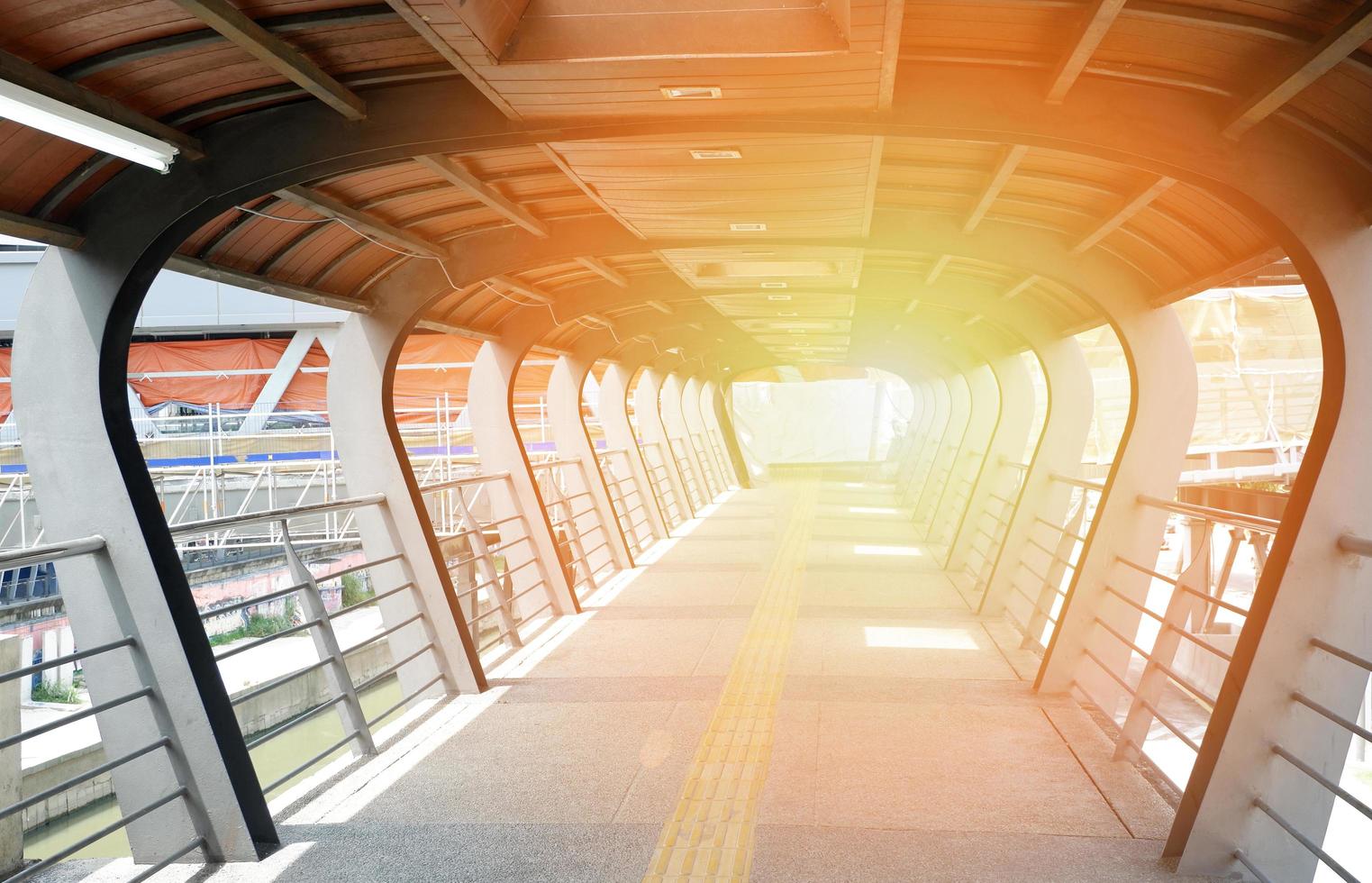 pedestrian overpass -  modern footbridge overpass crossing on traffic and river with light at the end photo