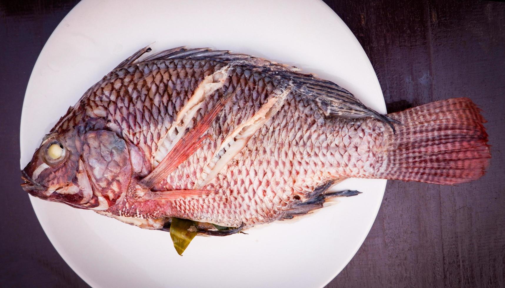 fish steam herb and Vegetable on plate Steamed tilapia fish photo