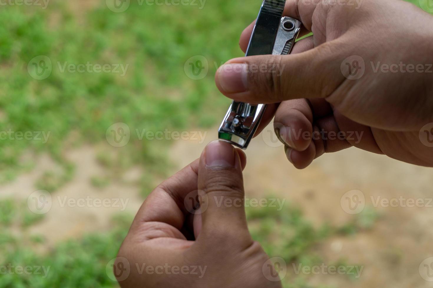 mano corte uñas con clíper. hombres mano participación metal uñas cortador foto