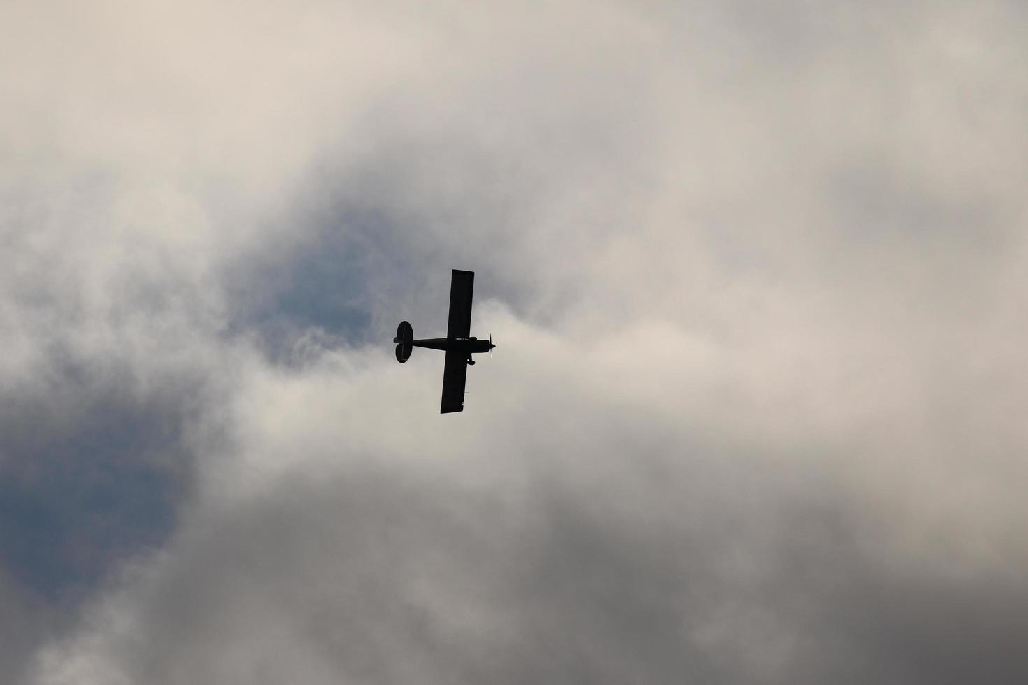 Small plane flying in the sky against dark clouds photo