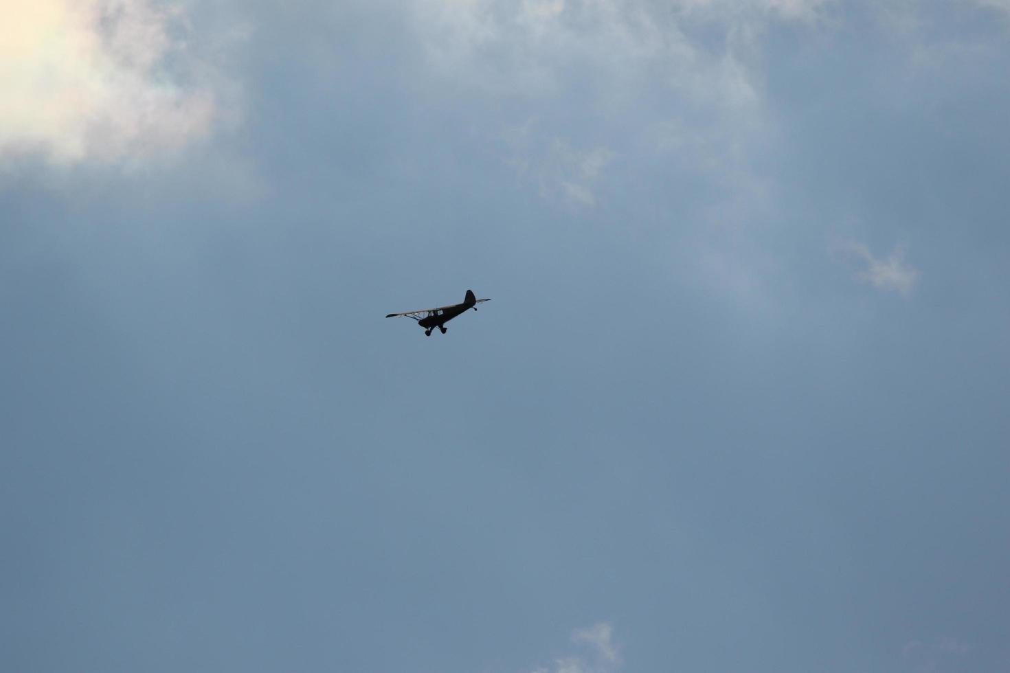 Small plane flying on a blue sky photo