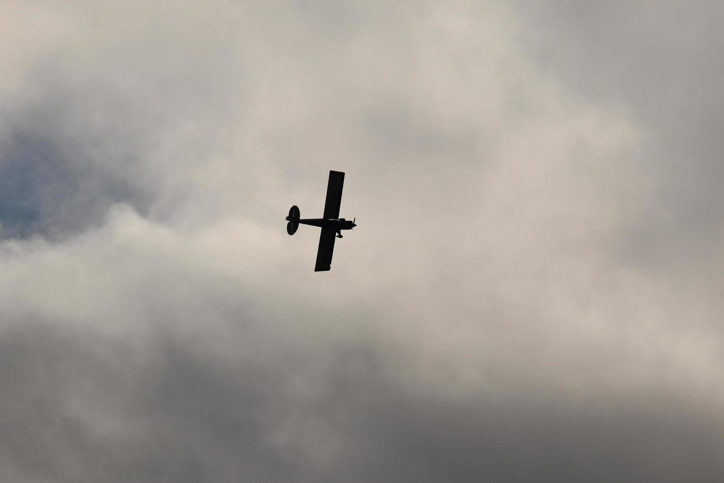 Small plane flying in the sky against dark clouds photo