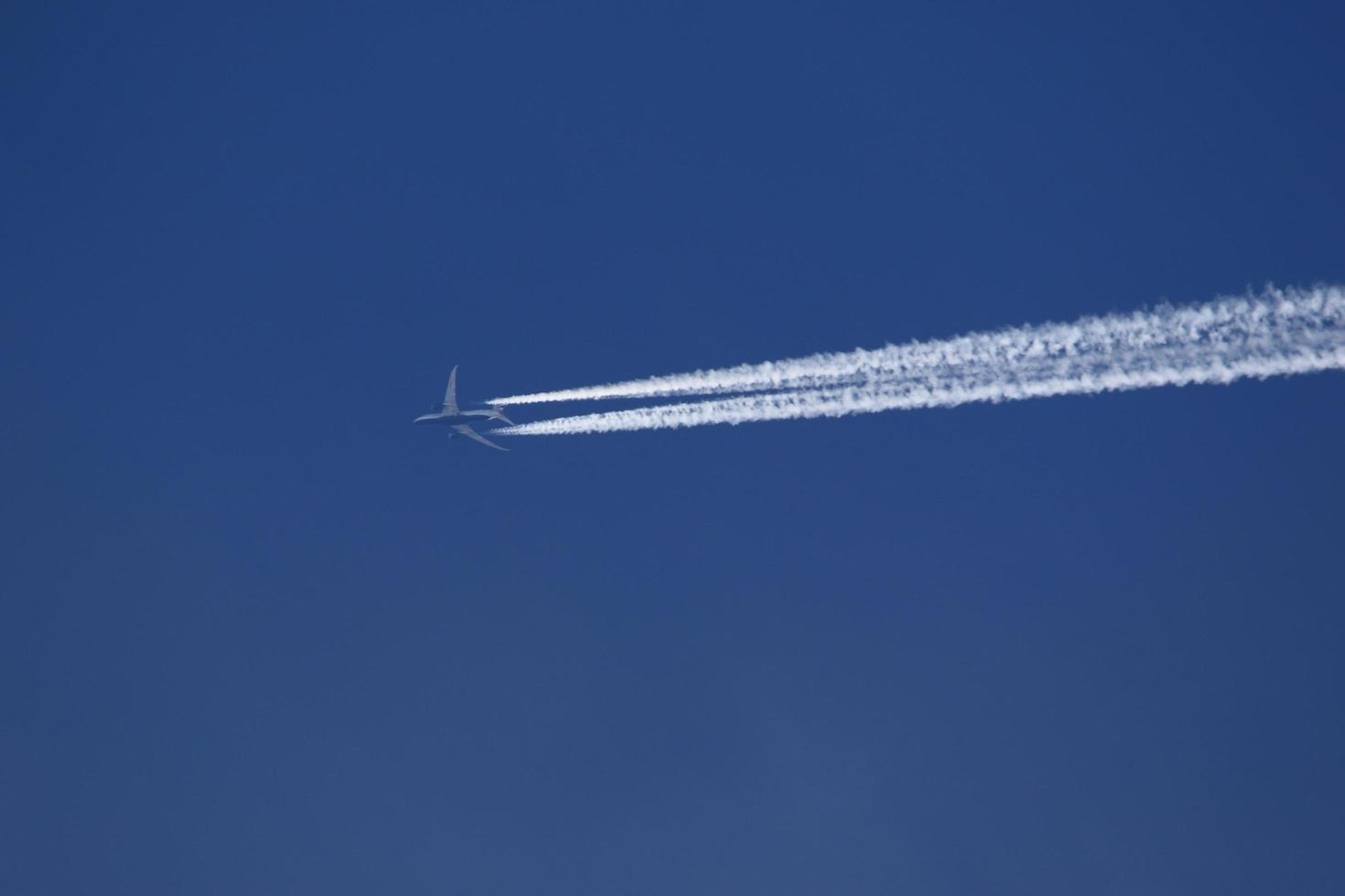 A plane and vapor trails in the sky photo