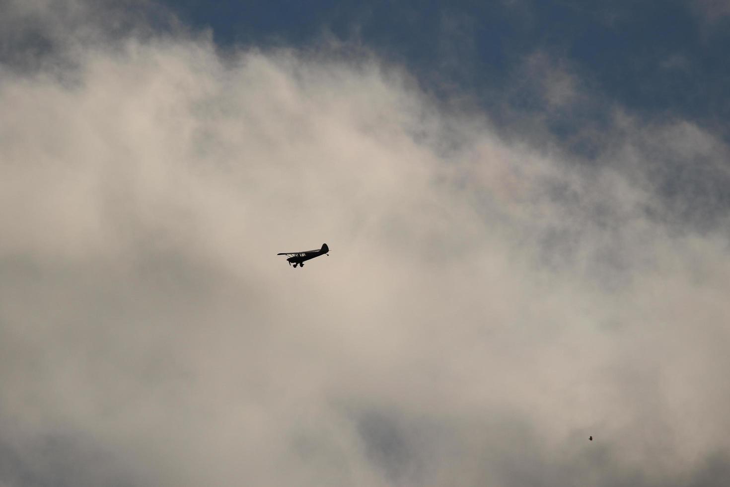 Small plane flying in the sky against dark clouds photo