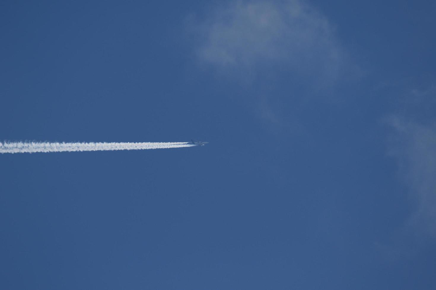 A plane and vapor trails in the sky photo