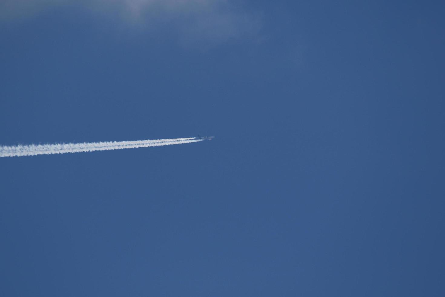 A plane and vapor trails in the sky photo