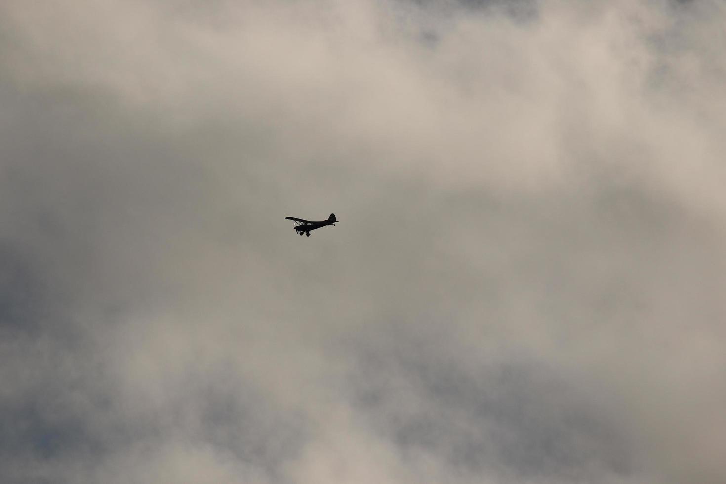 Small plane flying in the sky against dark clouds photo