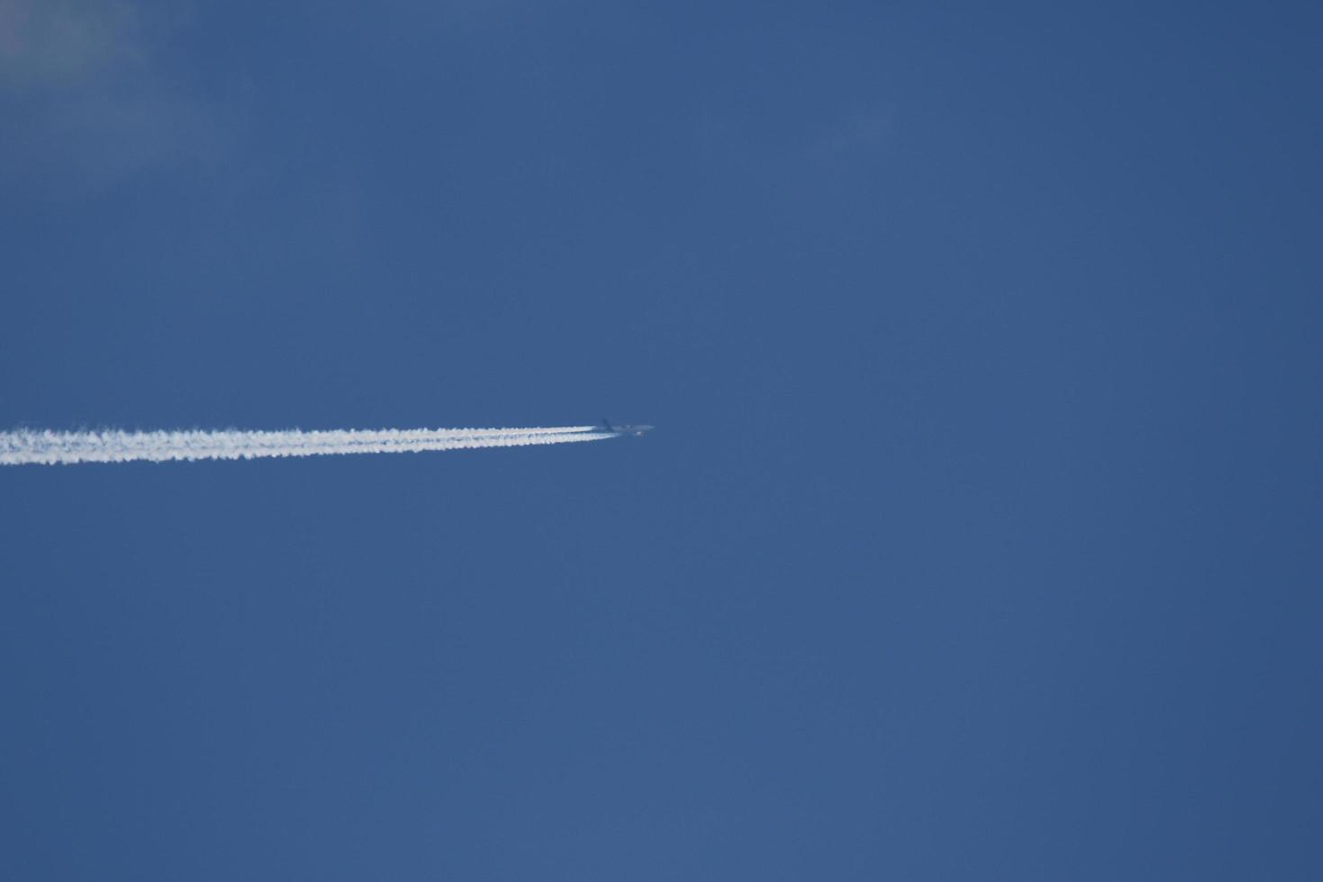 un avión y estelas de vapor en el cielo foto