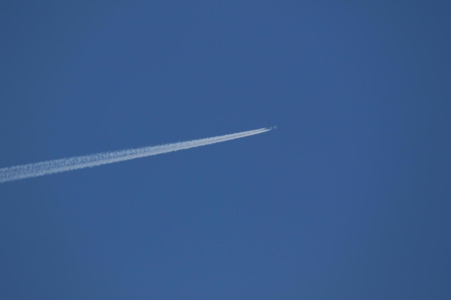 A plane and vapor trails in the sky photo