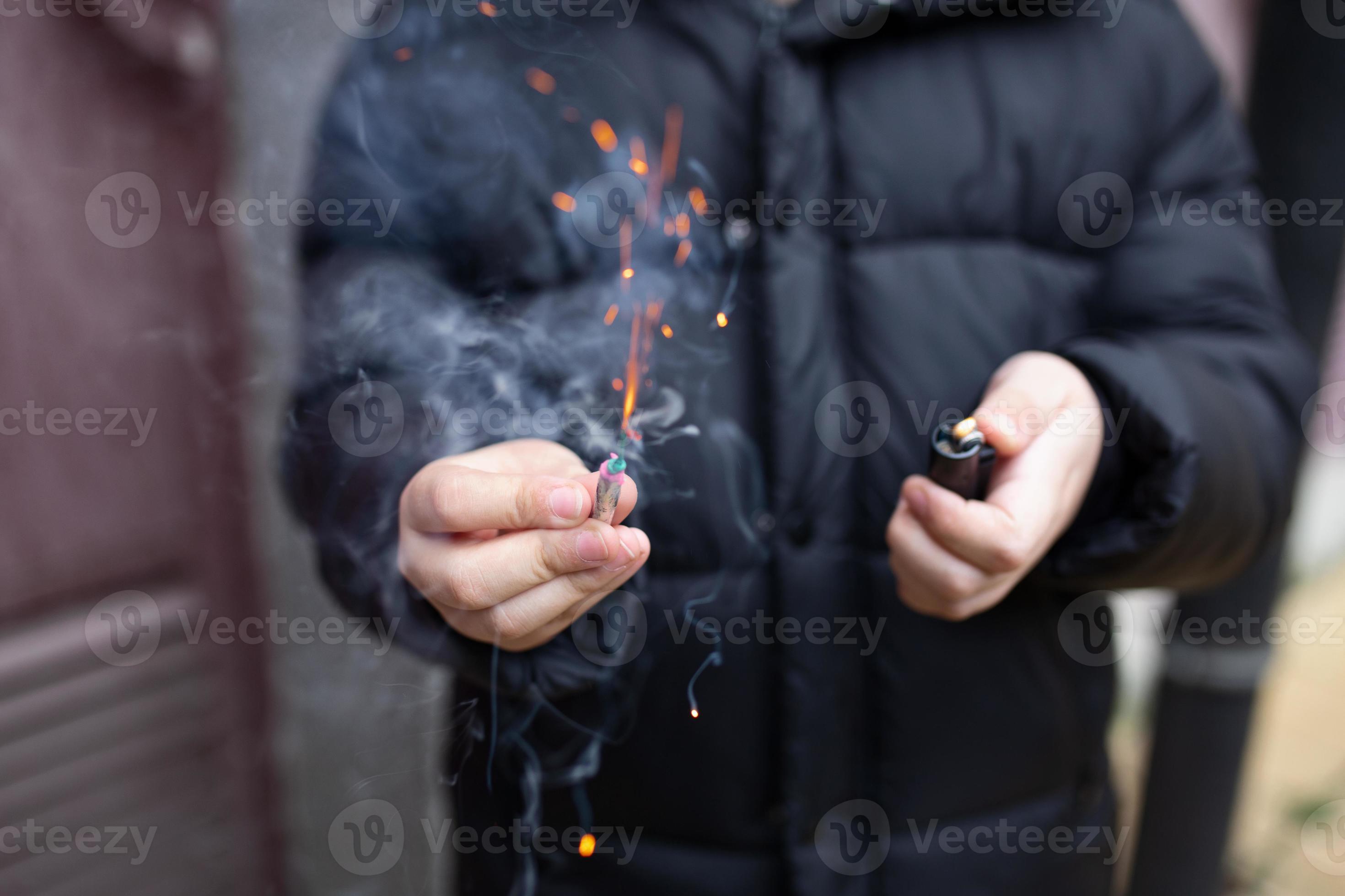 Premium Photo  Burning firecracker in a hand sparks and smoke of petard