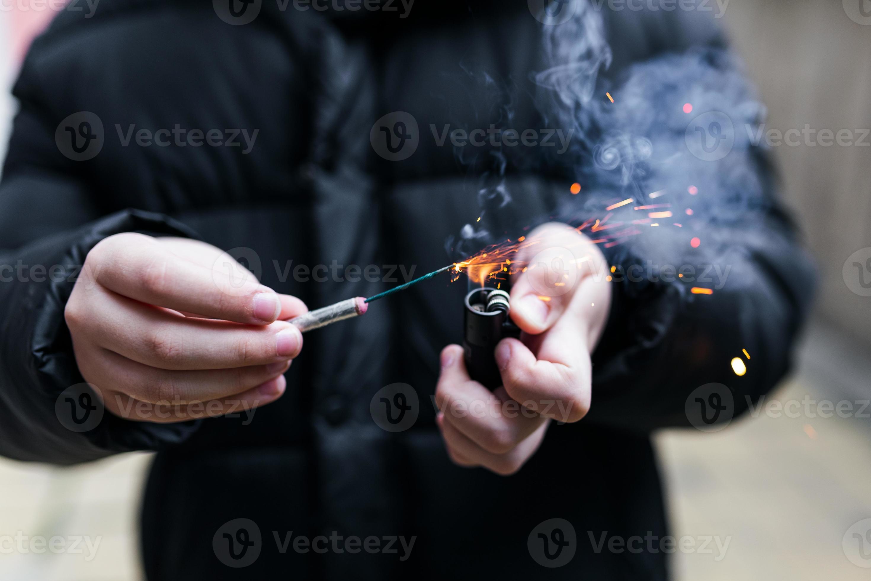 Premium Photo  Burning firecracker in a hand sparks and smoke of petard