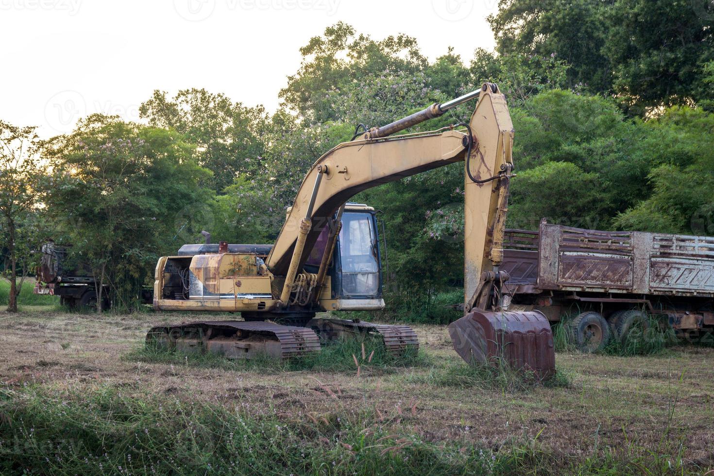 old backhoe on construction site in the green fields photo