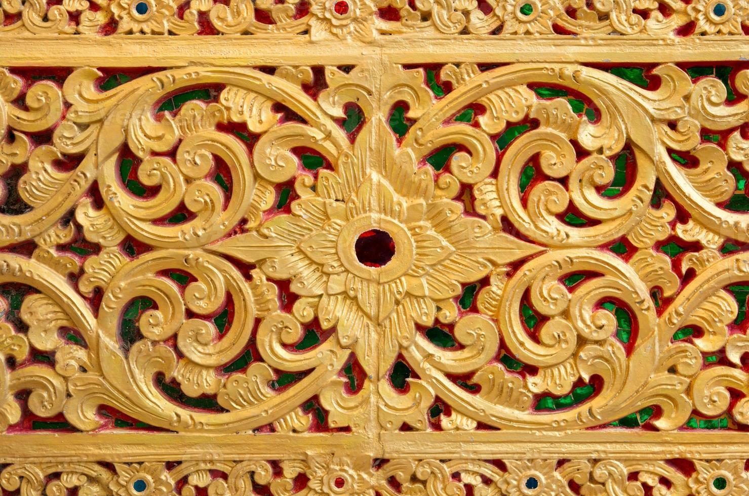 Pattern of gold flower carved on stone wall background, Thai style in temple photo