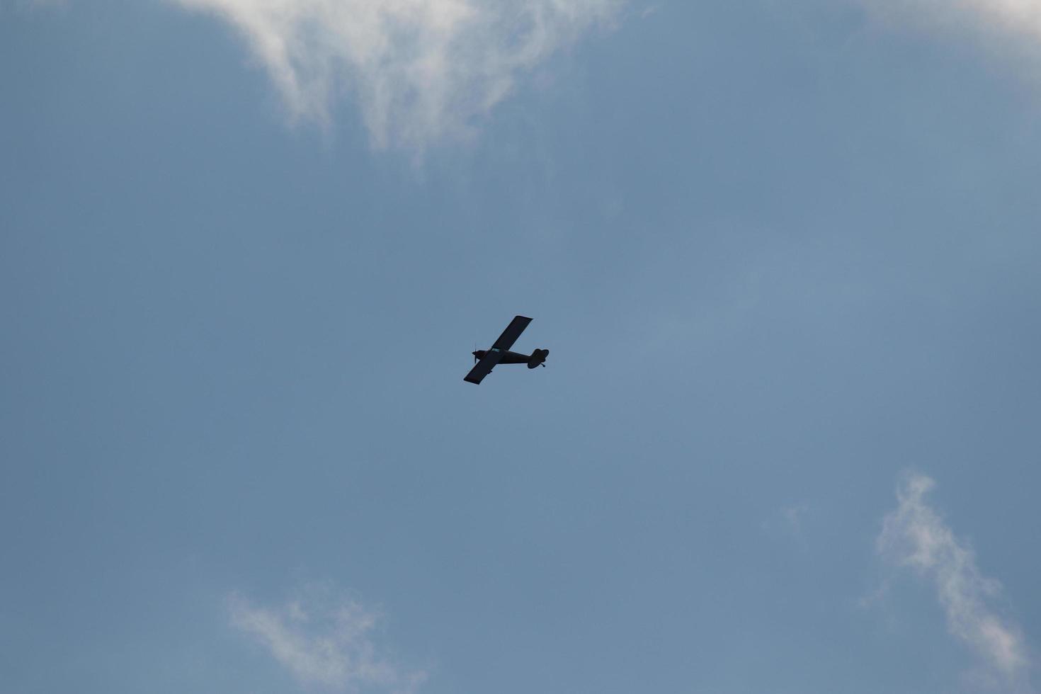 Small plane flying on a blue sky photo