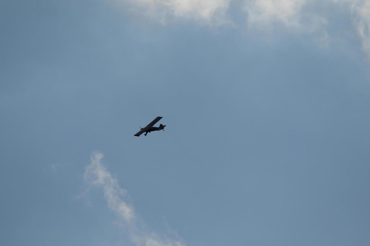 Small plane flying on a blue sky photo