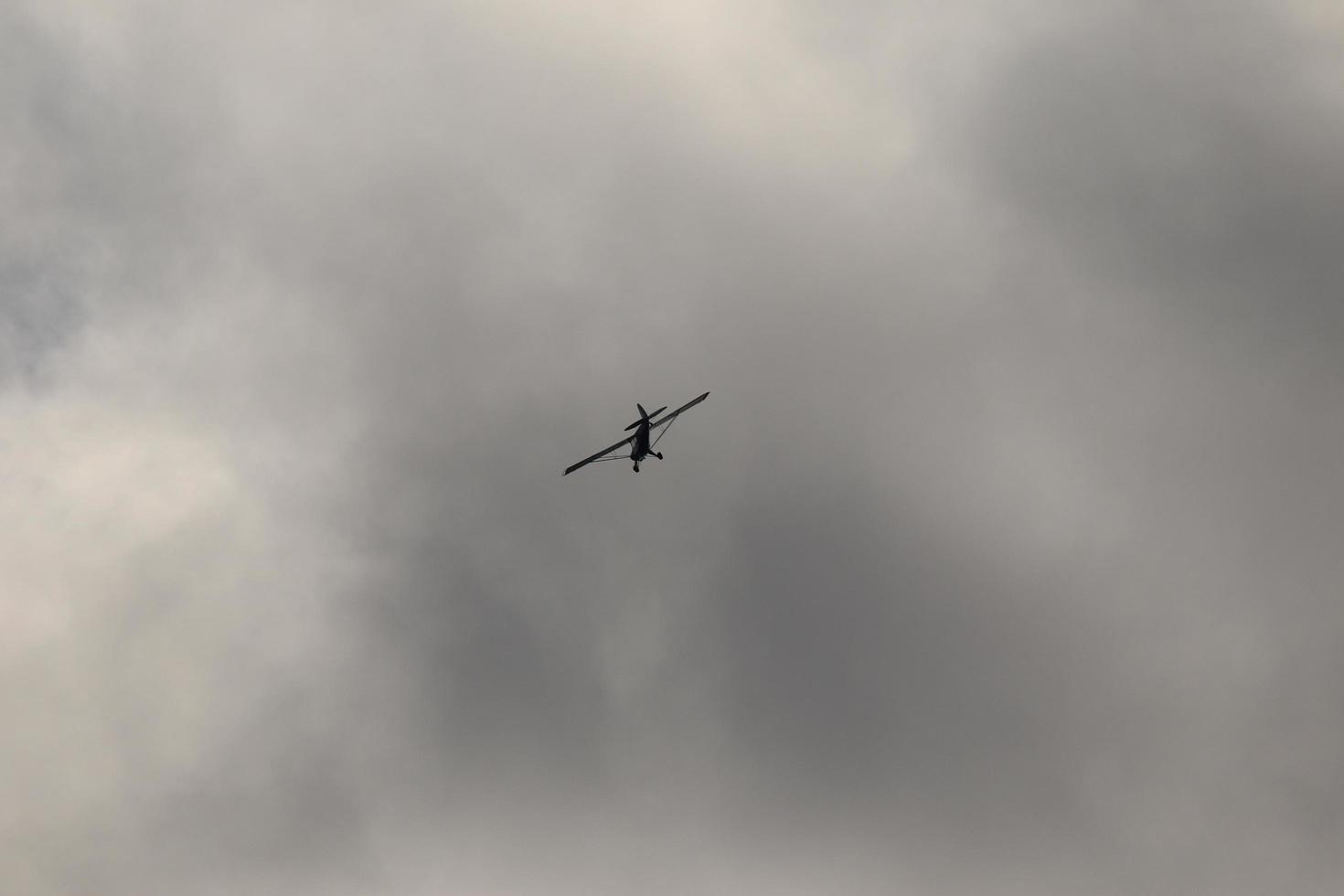 Small plane flying in the sky against dark clouds photo