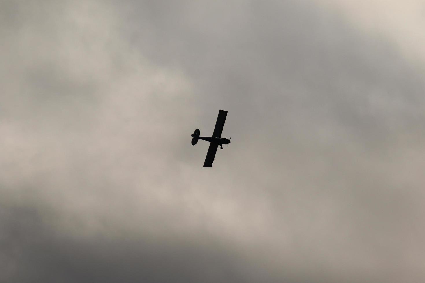 Small plane flying in the sky against dark clouds photo