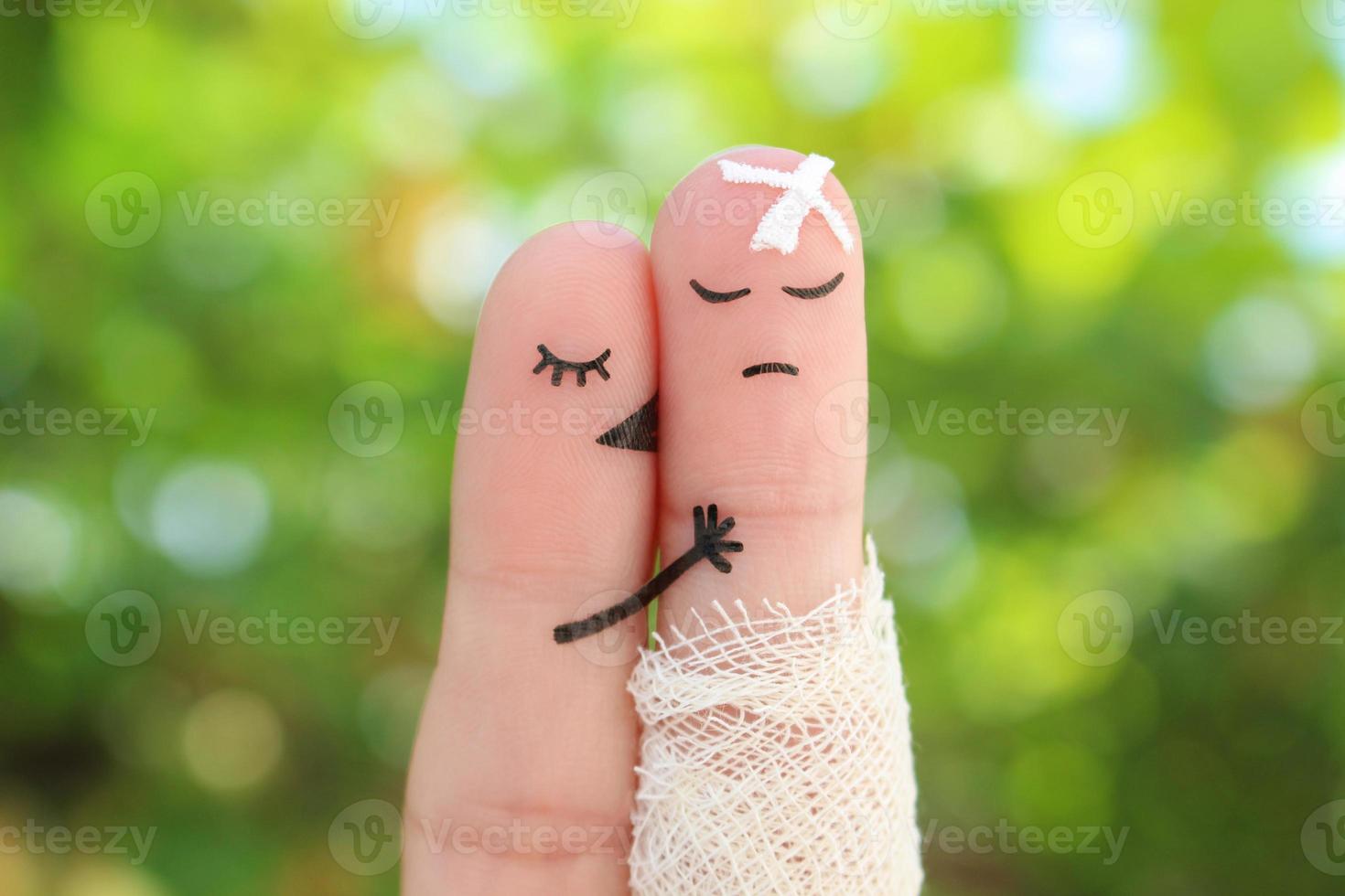 Fingers art of displeased couple. Man is sick, woman feels sorry for him. She kisses and hugs his. photo