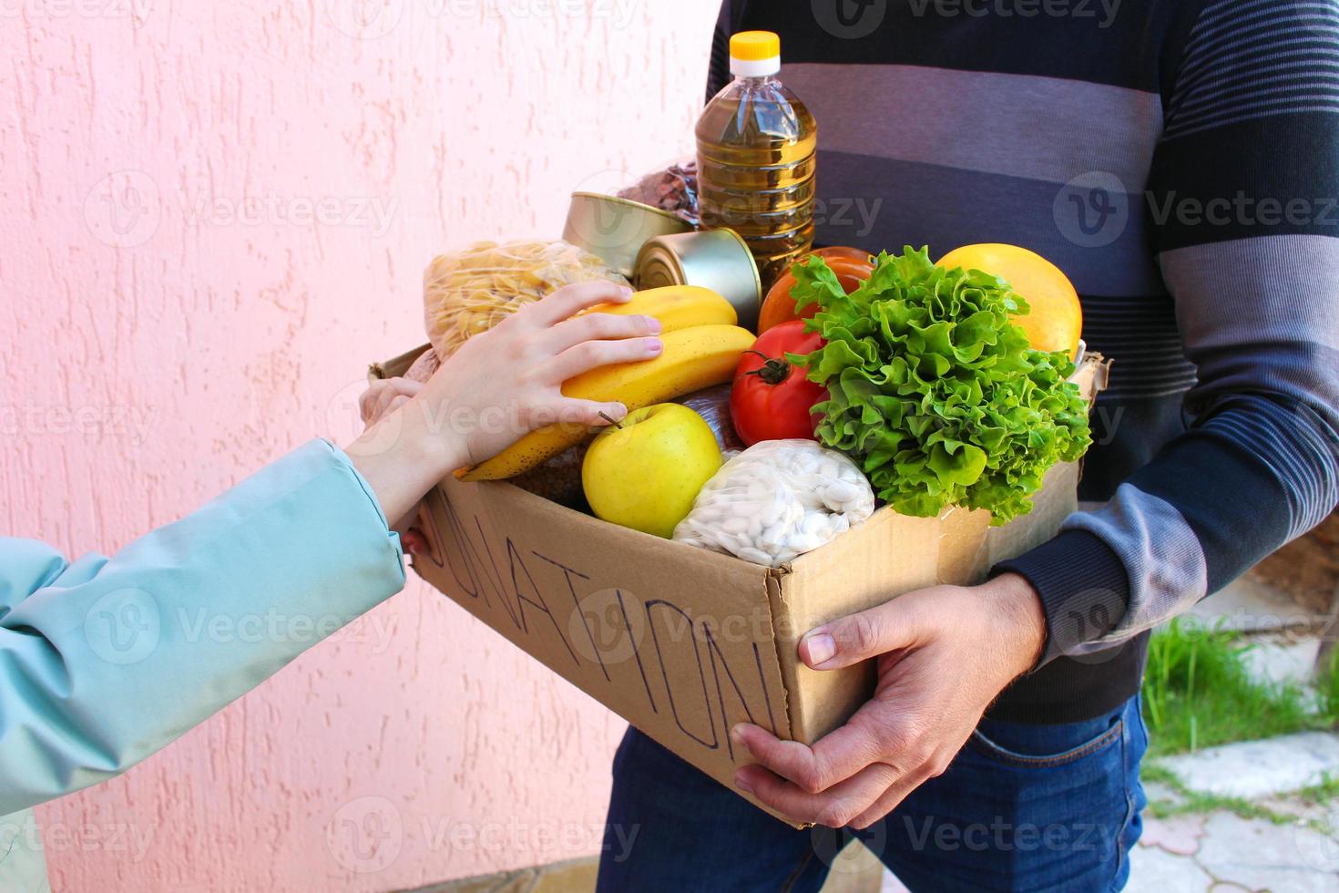 hombre sostiene donación caja con alimento. foto