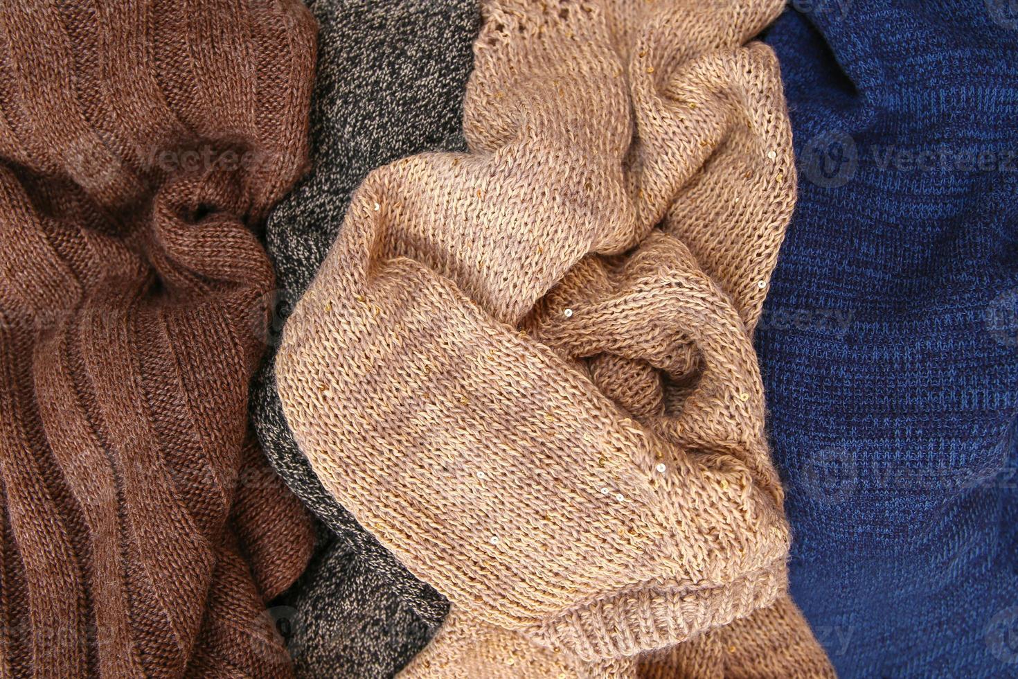 Pile of colorful warm clothes on wooden background. Top view. Flat lay. photo